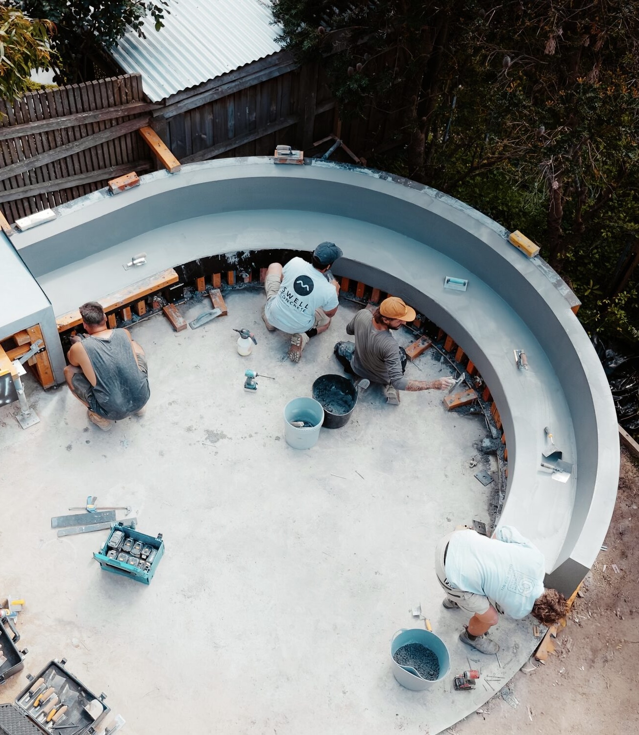 Crew troweling a curved backyard bench pour