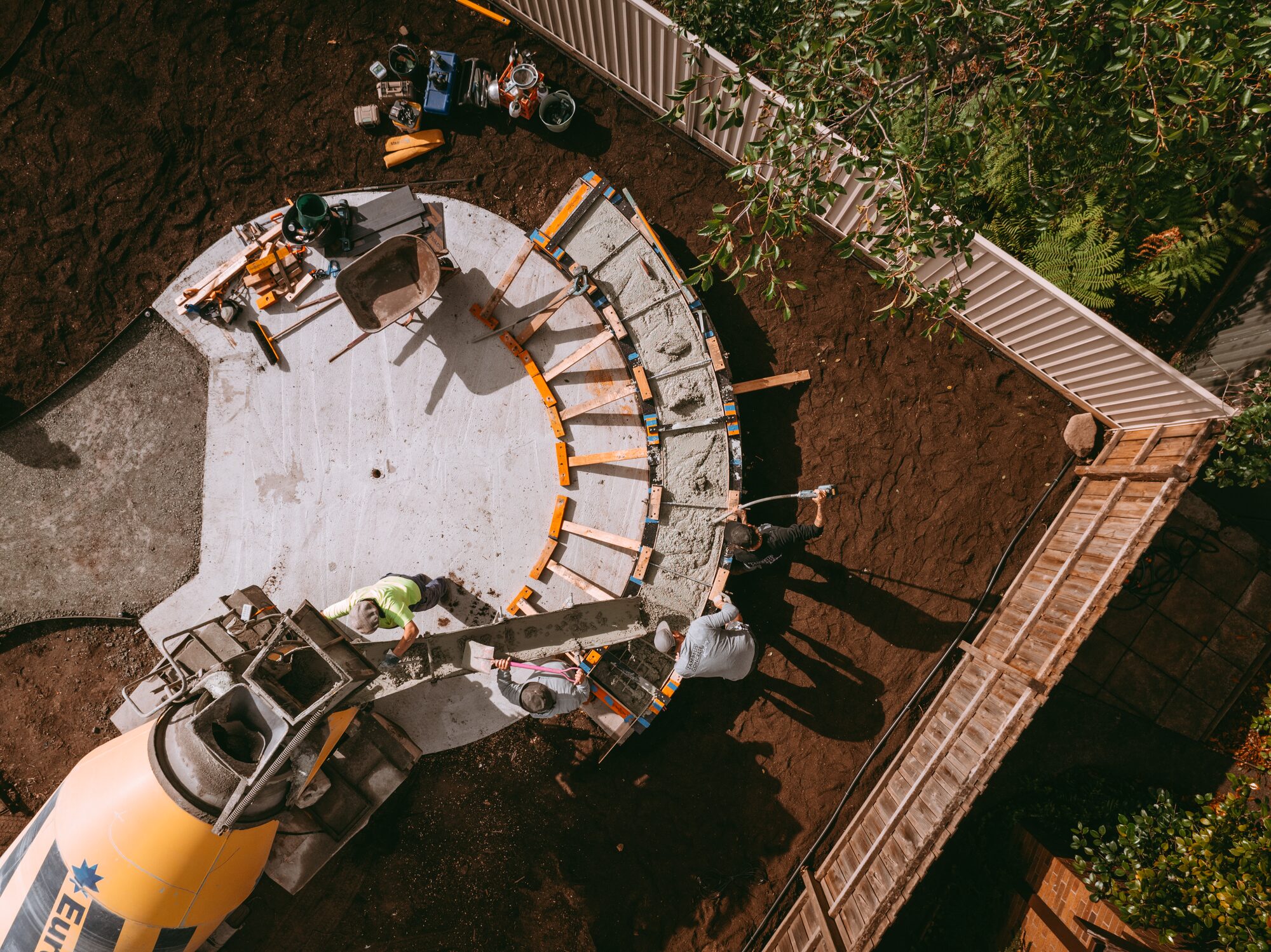 Aerial view of curved formwork being filled from a mixer chute
