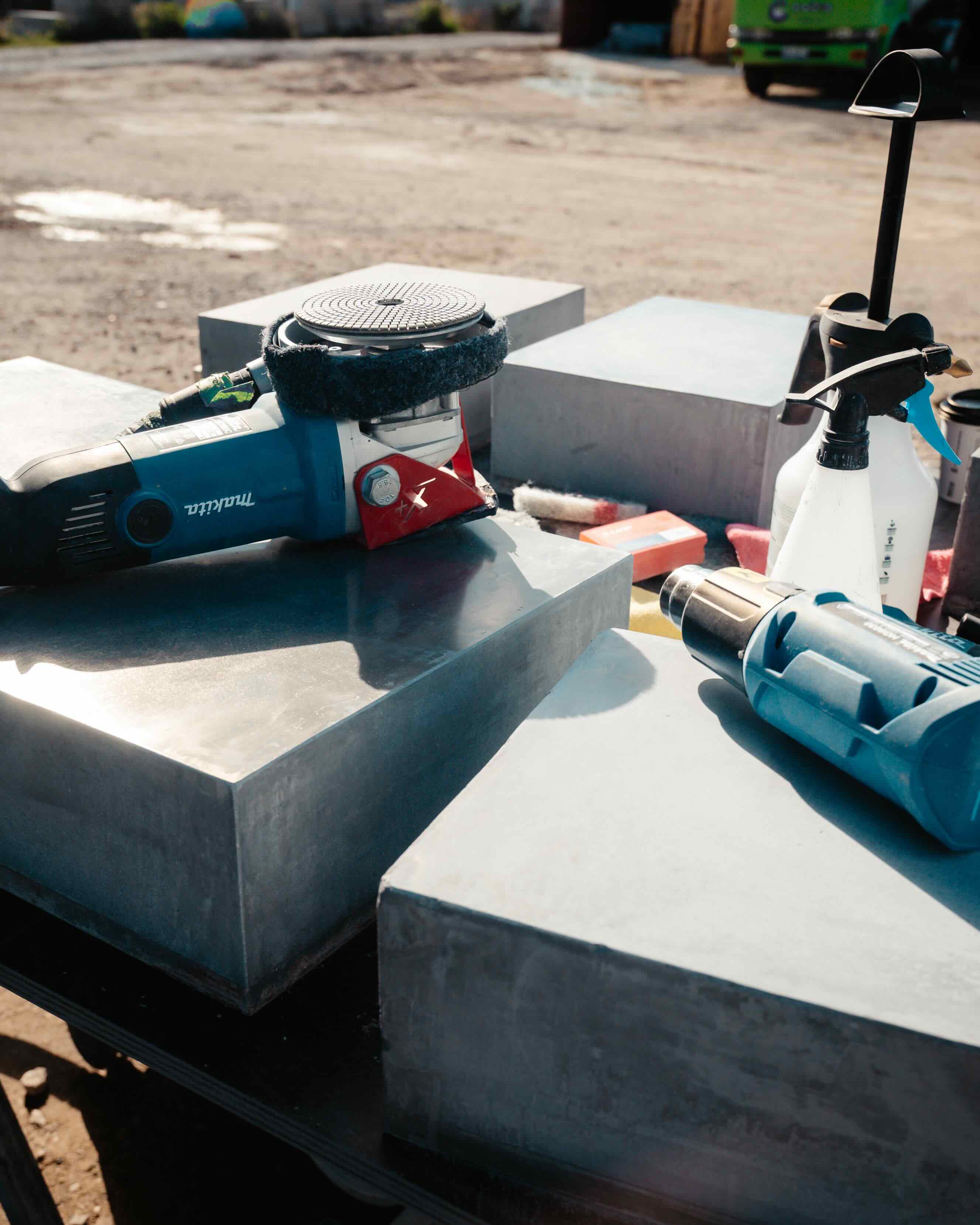 Makita grinder and workshop tools on concrete blocks in an outdoor training yard