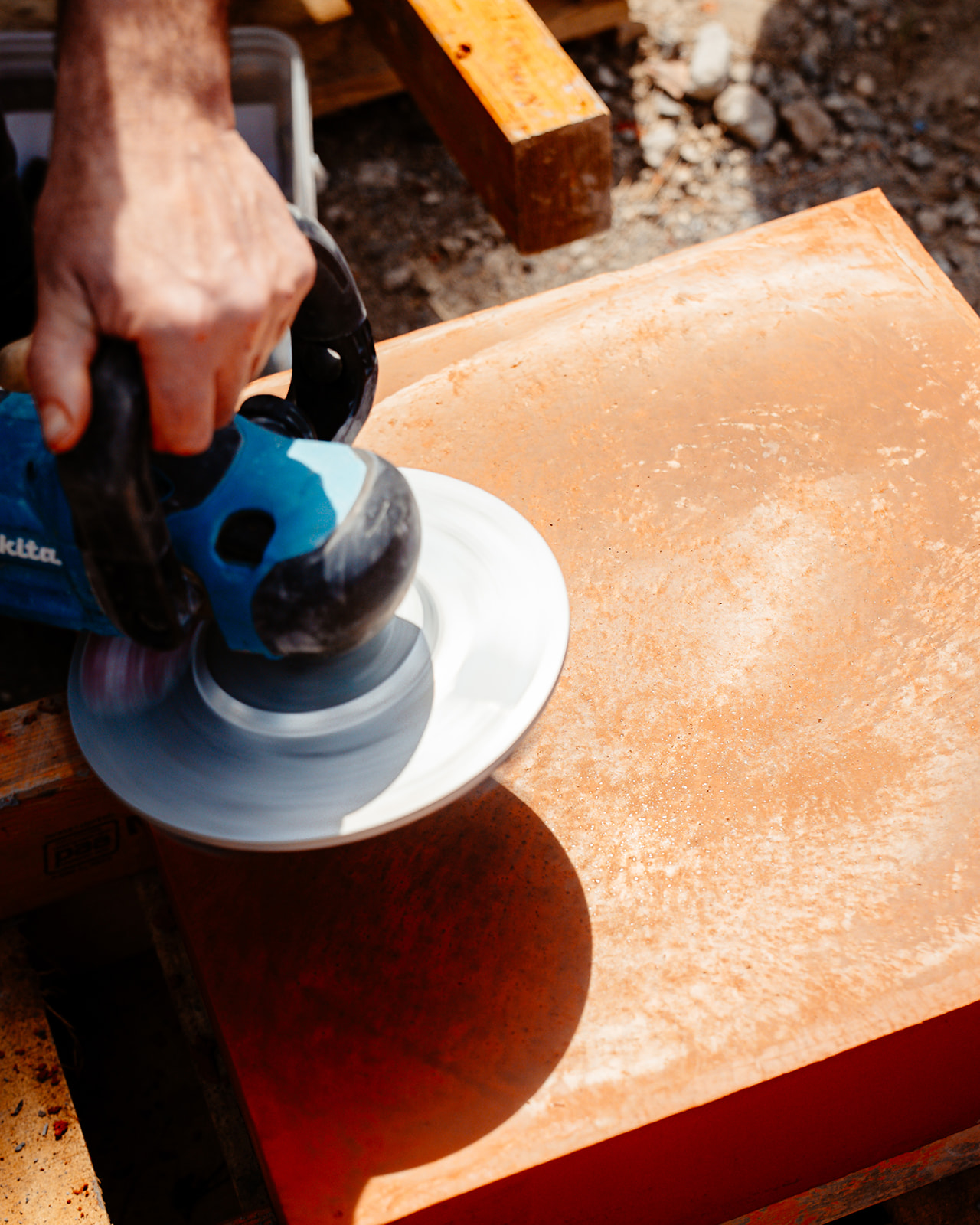 Close-up of Makita polisher on an orange-toned slab