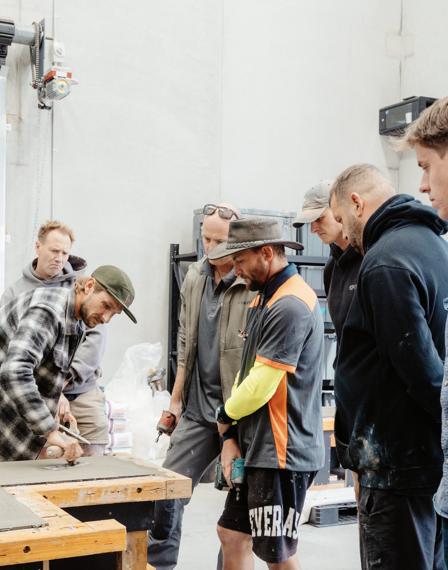Workshop group watching a troweling demonstration