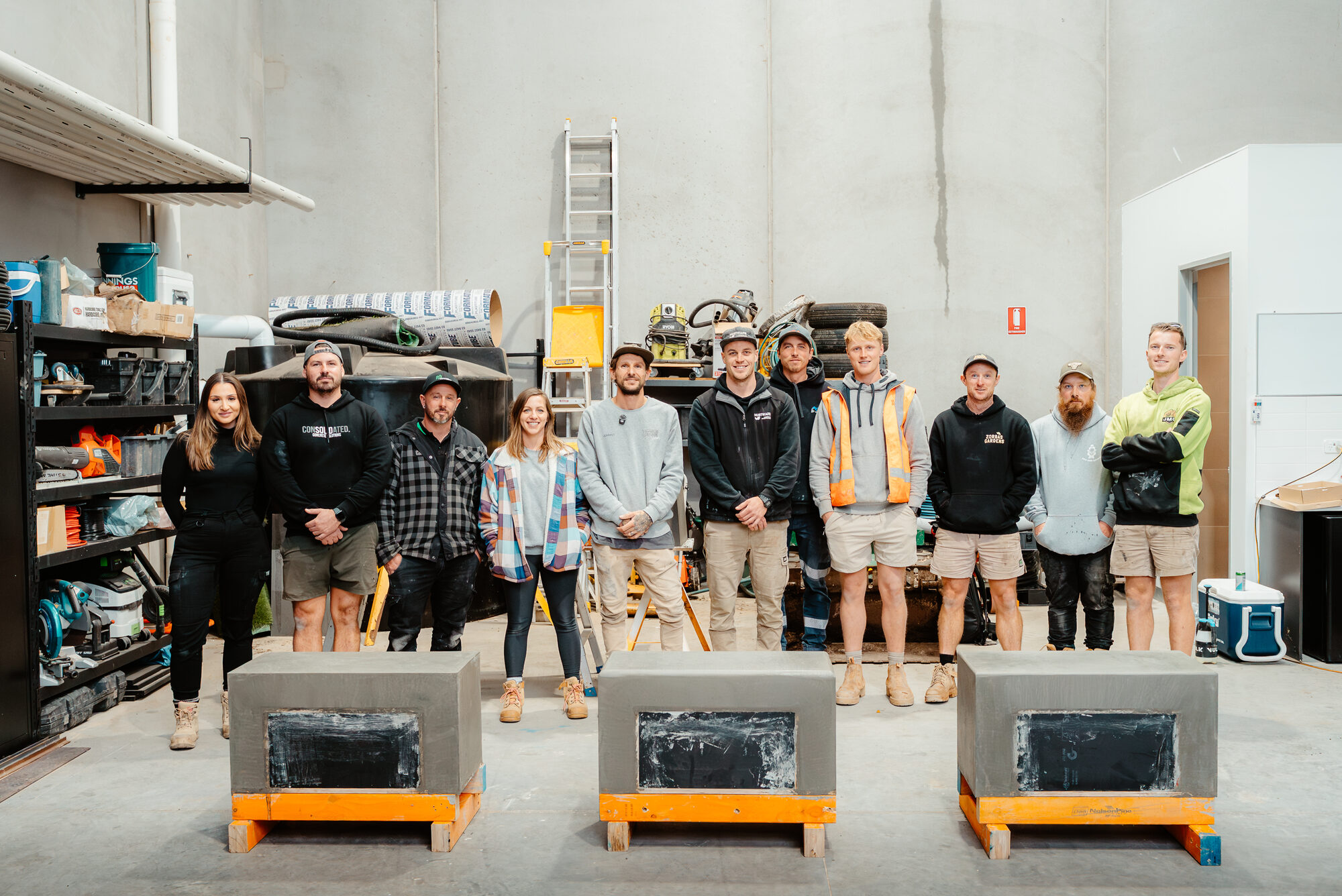 Workshop team standing behind three concrete fireplace forms